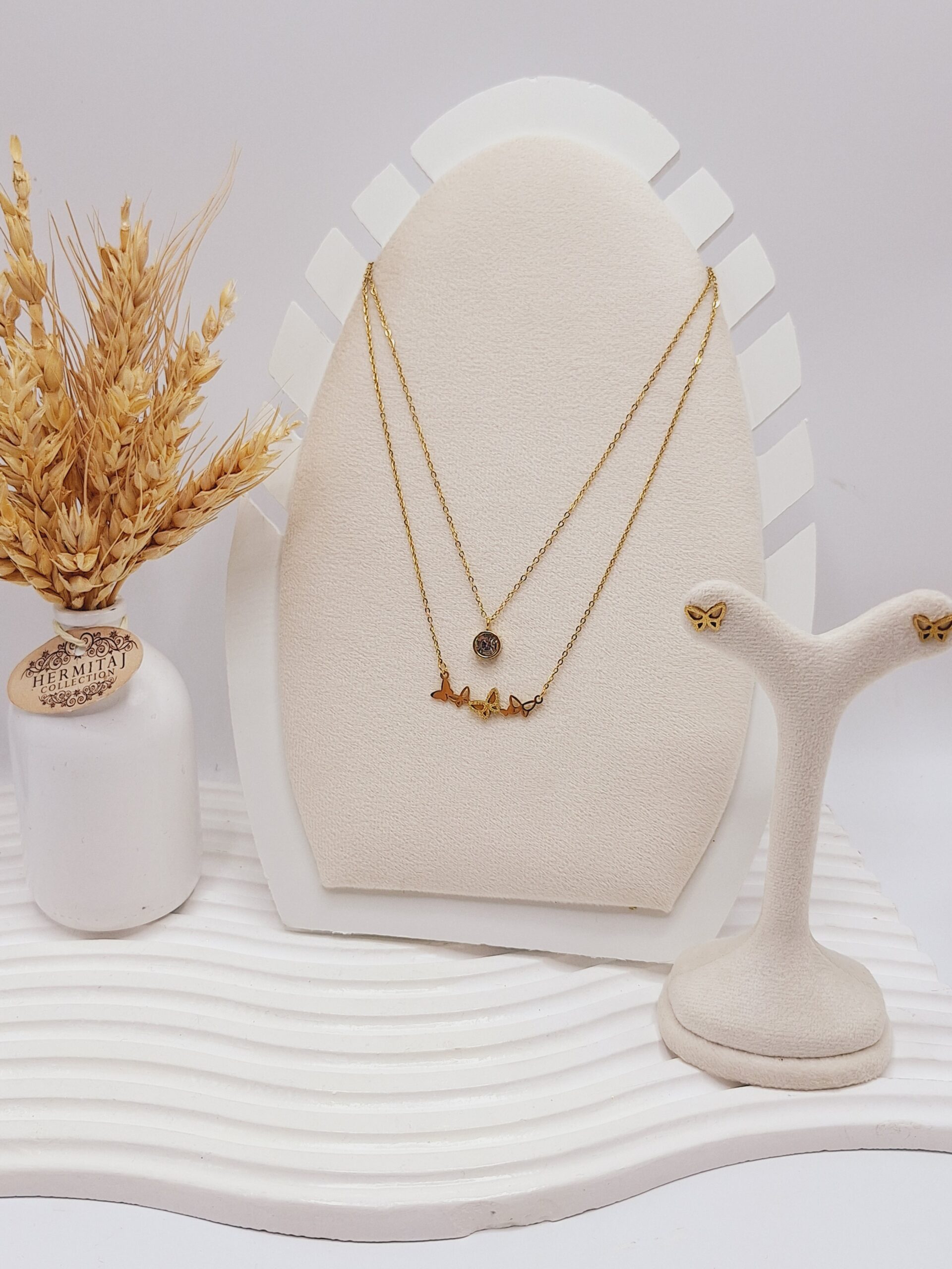ست گوشواره و گردنبند دو لاین پروانه های ریز و آویز نگین دار رنگ طلایی استیل