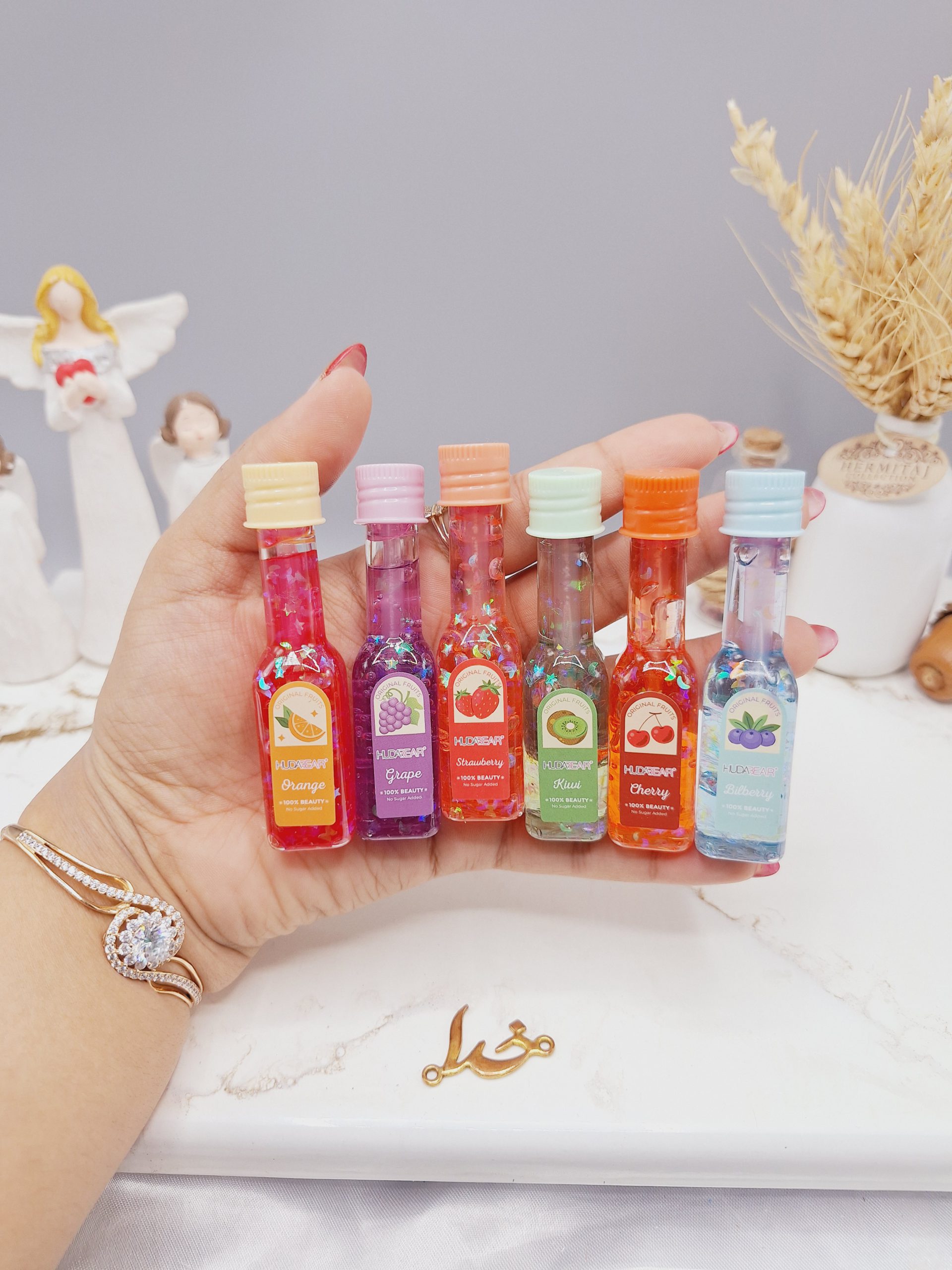 لیپ گلاس شاین دار طرح بطری شامپاین برند هدا بر HUDA BEAR کد M031